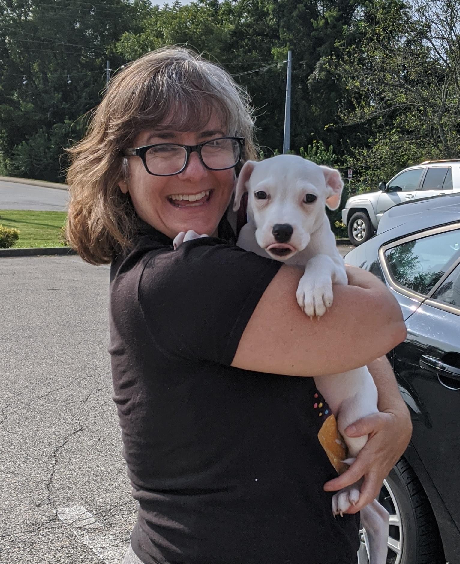 Tami holding an Adopted Pit Bull pup with a future hope of therapy dog potential.